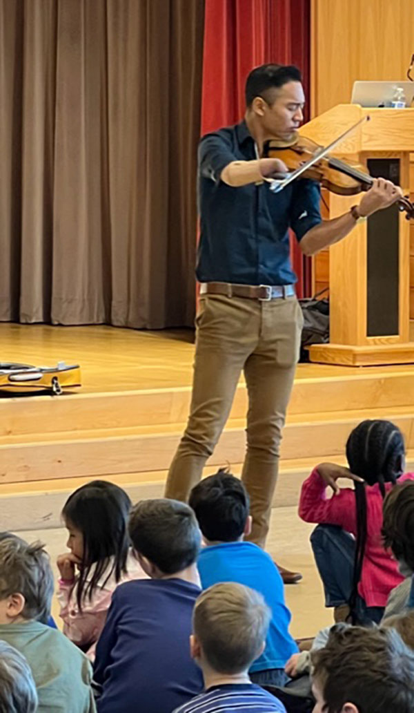 Adrian Anantawan plays his violin with one arm at Angier School in Newton